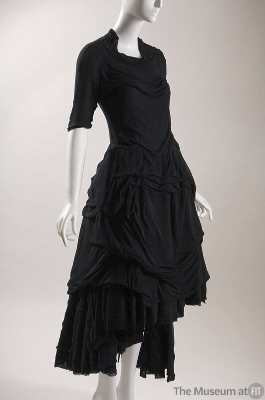 Black short sleeve dress with full draped skirt with uneven hem 