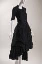 Black short sleeve dress with full draped skirt with uneven hem 