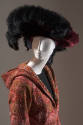 Detail of red hooded paisley print coat and red velevt hat with black faux fur trim
