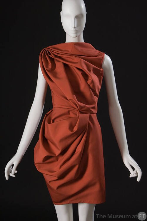 Orange sleeveless above-the-knee dress with draped and folded fabric 