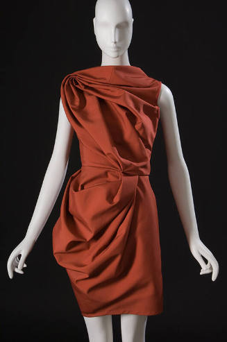 Orange sleeveless above-the-knee dress with draped and folded fabric 