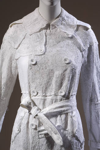 Detail of white embroidered cotton handkerchief double-breasted coat with belt 