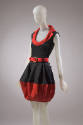 Black sleeveless top with red lapel collar, coordinating above-the-knee skirt with red belt and…