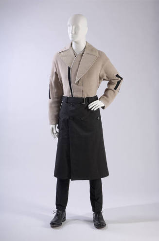 Beige long sleeve jacket with large lapels and black trim, black trench coat style skirt with b…
