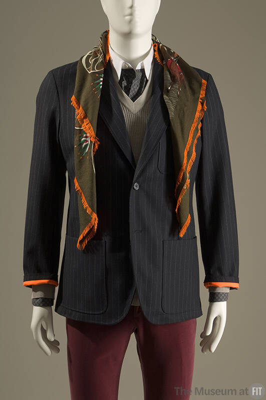 Navy blue pinstripe one button jacket with patch pockets, green silk scarf and red pants 