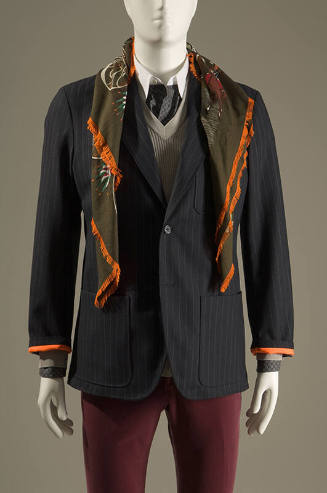Navy blue pinstripe one button jacket with patch pockets, green silk scarf and red pants 