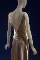 Back detail of sleeveless low button back beige silk slip style evening dress 