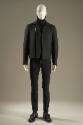 Grey long sleeve zip front jacket with zipper pockets over black turtleneck sweater and black s…