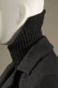 Detail of ribbed black knit turtleneck sweater and grey suit jacket 