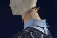 Detail of tan knit button back high collar and blue shirt collar 