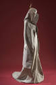 3/4 view of grey sleeveless cape with high collar and matching floor length dress with train 