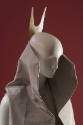 Detail of grey sleeveless vest with high collar and large forked bone hair ornament