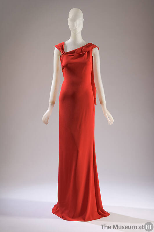 Red sleeveless silk evening dress with knotted and draped shoulder, floor length with train