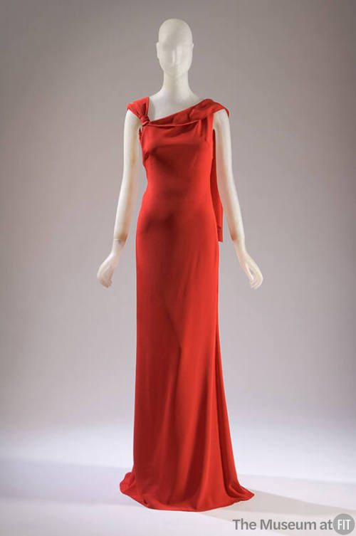 Red sleeveless silk evening dress with knotted and draped shoulder, floor length with train