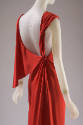 Detail 3/4 view of red sleeveless silk plunge back evening dress with knotted and draped should…