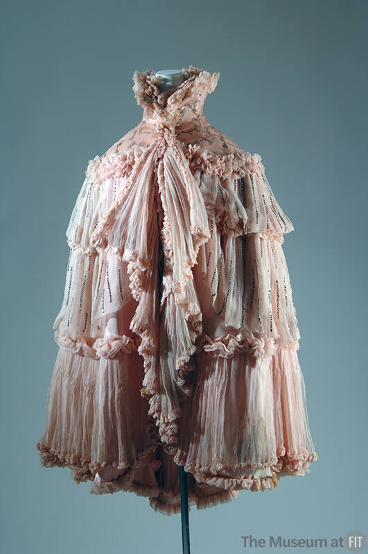 Pink evening cape with wide beaded collar and tiers of pleated ruffles edged with ruching and a…