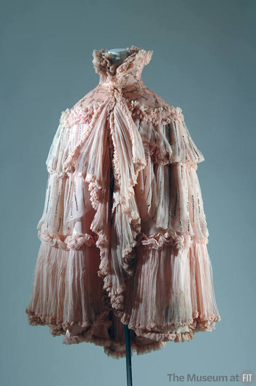 Pink evening cape with wide beaded collar and tiers of pleated ruffles edged with ruching and a…