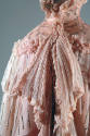 Detail view of pink evening cape showing silver scrolling floral beadwork on collar and tiers o…