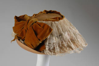 Peach straw basket shaped hat with gathered ivory lace panel over brim and large brown velvet r…