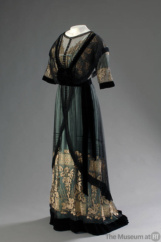 Aqua floor length dress with short sleeve black net overbodice with cream floral embroidery on …