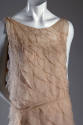 Detail view of pink chiffon evening dress showing of graduating scalloped diagonal flounces and…