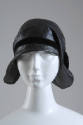 Black straw cloche hat with black velvet ribbon band and asymmetrical brim flattened against bo…