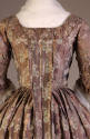 Back view of violet and pink robe à la française dress showing pleated panel extending down bac…
