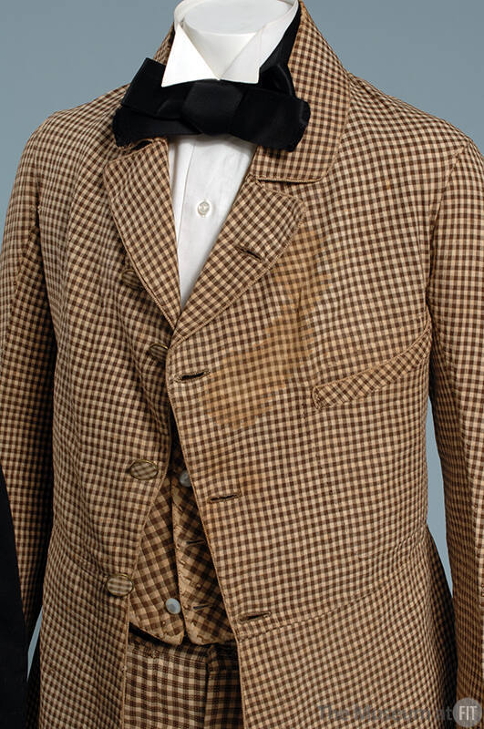 Man’s brown and beige check three-piece suit with varying check patterns on jacket, vest and pa…