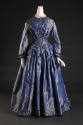 Iridescent blue silk floor length dress with long bell sleeves and pleating of bodice and of fu…