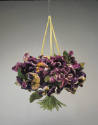 Bag in the shape of a bouquet of purple, yellow and white pansy flowers with gathered green ste…