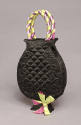 Black quilted silk bag in the shape of a vase with purple and green ribbon bow on foot and wrap…