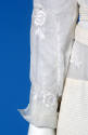 Detail view of white afternoon dress showing left sleeve with white floral embroidery and openw…