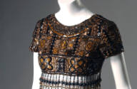 Detail view of brown beaded evening mini dress showing geometric pattern of plaques and beads a…