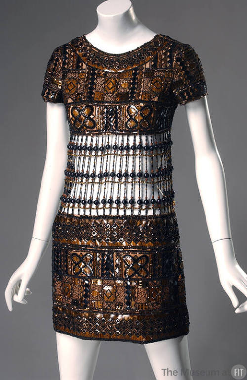 Brown short sleeve mini evening dress with geometric plaques in black, brown and ochre outlined…