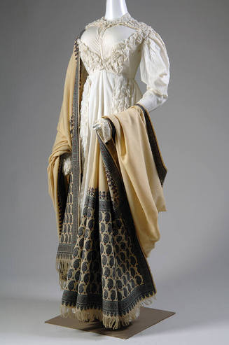 Short white jacket and matching floor length skirt trimmed with rows of puffs and off-white sha…