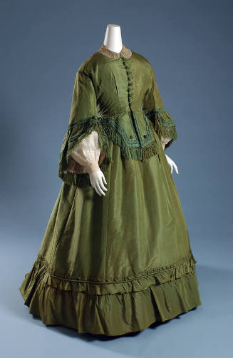 Green silk two-piece floor length dress of button front bodice with long bell sleeves, peplum a…
