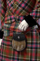 Detail view of man’s tartan ensemble showing waist tie with slightly different tartan pattern a…