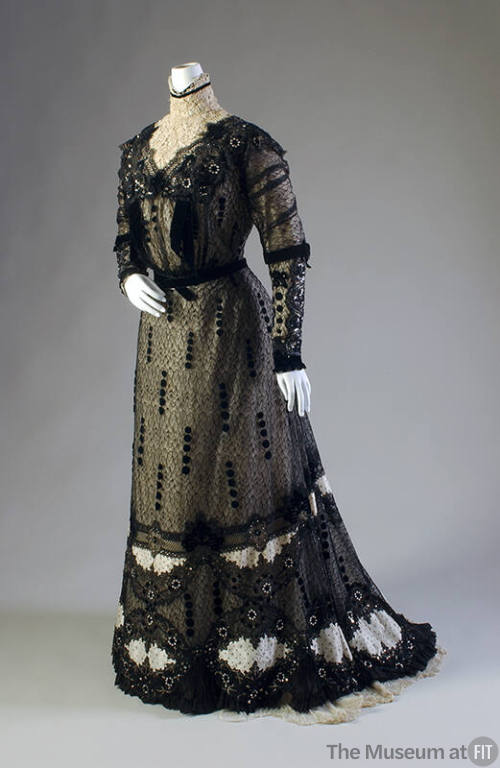 Black lace long sleeve floor-length dress with high off-white lace collar, velvet and beaded tr…
