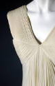 Detail of pleated white silk sleeveless dress V-neck bodice