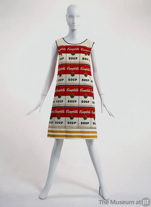 White sleeveless shift dress with allover Campbell's soup cans in red and yellow, black trim