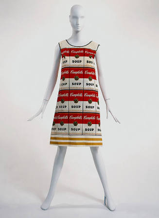 White sleeveless shift dress with allover Campbell's soup cans in red and yellow, black trim