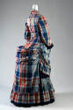 Back view of blue, red, beige tartan long sleeve button back dress with back bustle and floor-l…