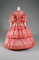 Orange satin button front bell sleeve dress with full gathered hoop skirt and fringe trim