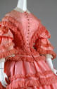 Bodice detail of orange satin button front bell sleeve dress fringe trim, lace collar