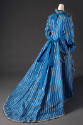 Back view of blue and white stripe silk dress, blue ribbons at neck and waist, floor-length ski…