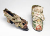 off white shoes with large, embroidered floral design with small heel. right shoe is cleaned an…