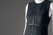 Detail of black square patch sleeveless dress with black belt and long vertical strap