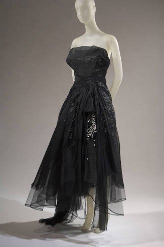 Black strapless evening dress with sheer over layer gathered at waist over white sqiggle design…