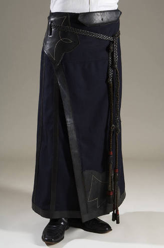 Floor-length blue wool wrap skirt with black leather trim and braided leather side ties