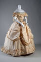 Cream silk two-piece floor length dress of off-the-shoulder cap sleeve bodice with ruffle V-sha…